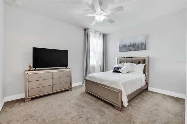 bedroom with ceiling fan and light carpet