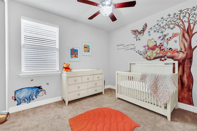 2599 Nouveau Way, Kissimmee, FL 34741 - bedroom featuring baseboards, light colored carpet, a crib, and a ceiling fan