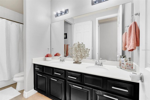 bathroom featuring tile patterned flooring, a shower with curtain, vanity, and toilet