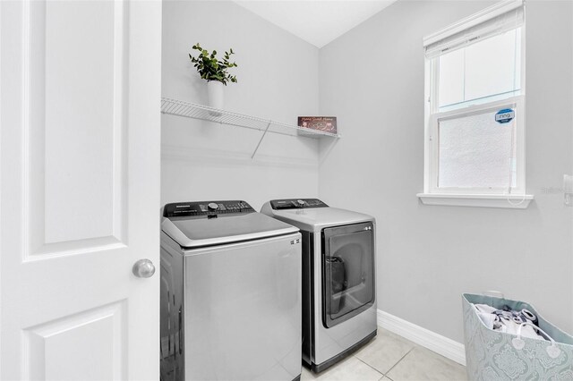 laundry area featuring washer and clothes dryer and light tile patterned floors