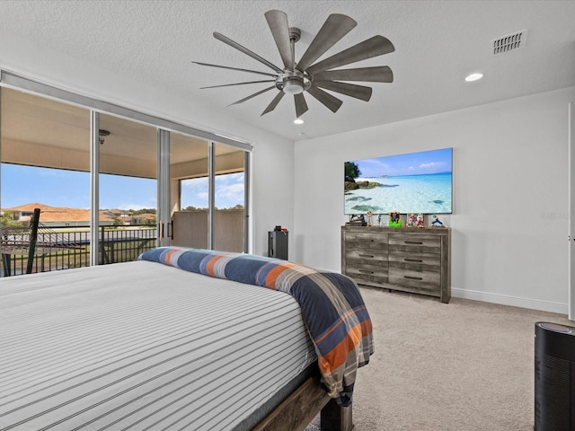 bedroom with ceiling fan, a textured ceiling, carpet floors, and access to exterior