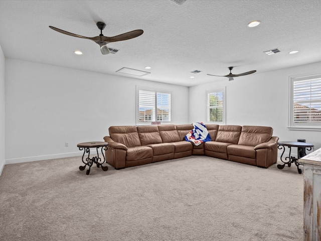 living room with carpet, ceiling fan, a textured ceiling, and plenty of natural light