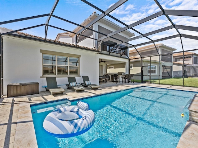 view of pool featuring a patio, ceiling fan, and glass enclosure