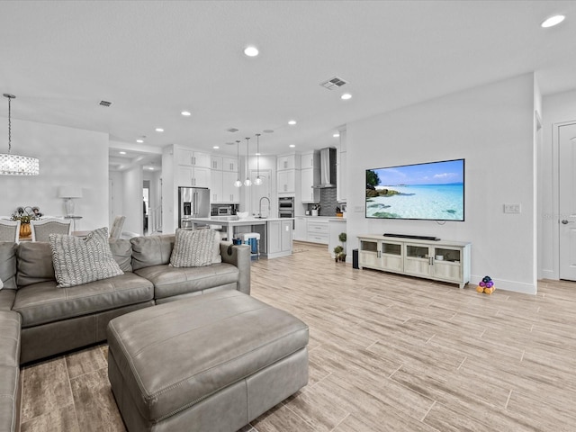 living room with light hardwood / wood-style floors and sink