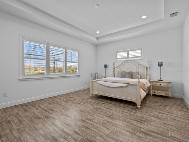 bedroom featuring a textured ceiling and a tray ceiling