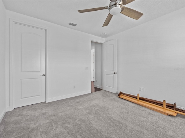 carpeted spare room featuring ceiling fan