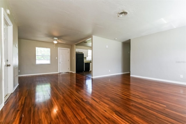 unfurnished living room with ceiling fan and dark hardwood / wood-style floors