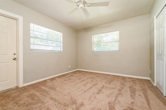 carpeted spare room with a healthy amount of sunlight and ceiling fan