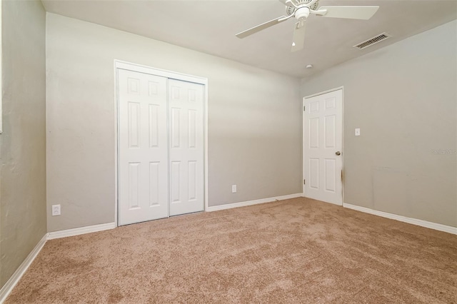 unfurnished bedroom featuring carpet floors, ceiling fan, and a closet