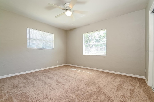 carpeted spare room featuring ceiling fan