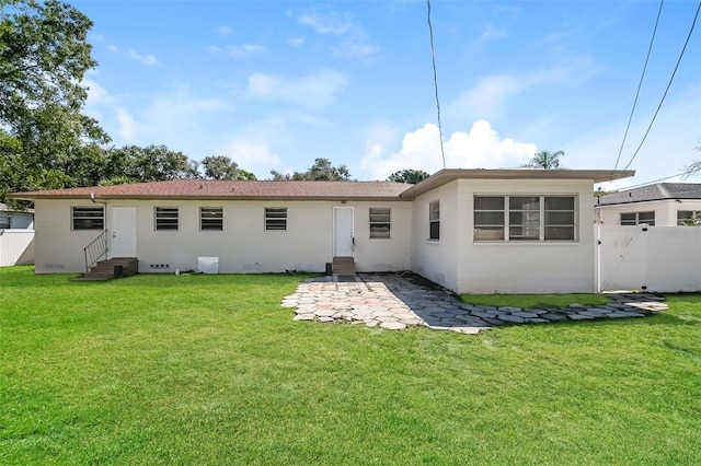 back of property featuring a lawn and a patio