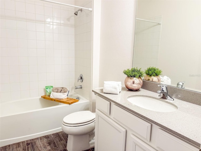 full bathroom with toilet, vanity, tiled shower / bath combo, and hardwood / wood-style flooring