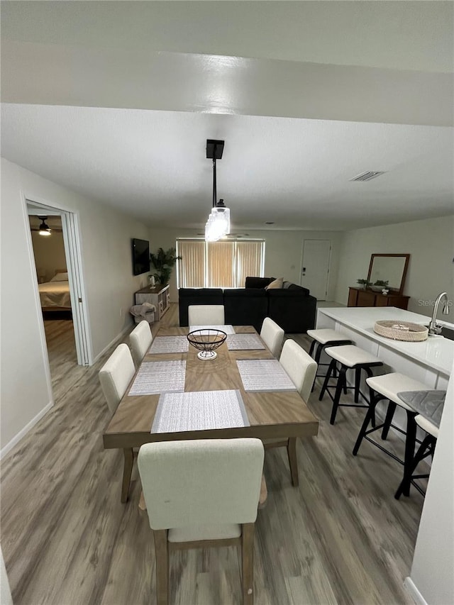 dining space with ceiling fan, hardwood / wood-style flooring, and sink