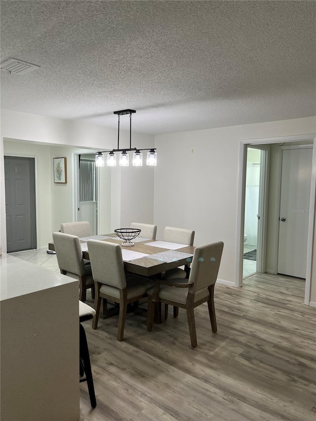 dining room featuring a textured ceiling and hardwood / wood-style flooring