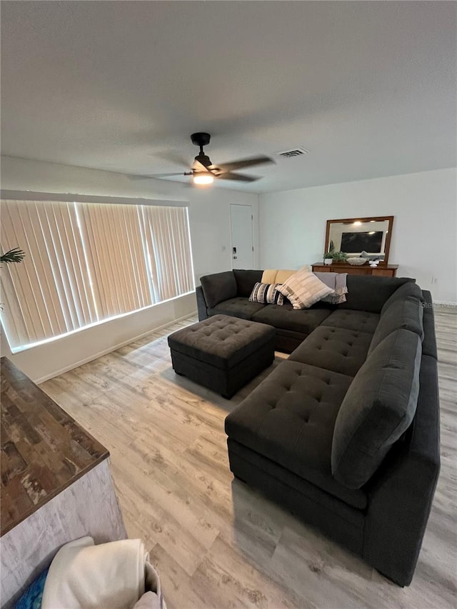 living room featuring ceiling fan and hardwood / wood-style flooring