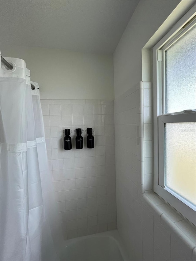 bathroom with a wealth of natural light and shower / bath combo