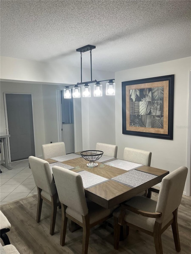 dining room with a textured ceiling and hardwood / wood-style floors