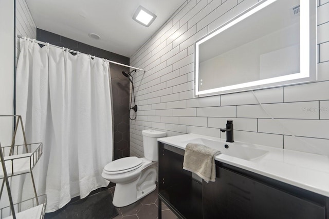 bathroom with toilet, a shower with curtain, tile walls, tile patterned floors, and vanity