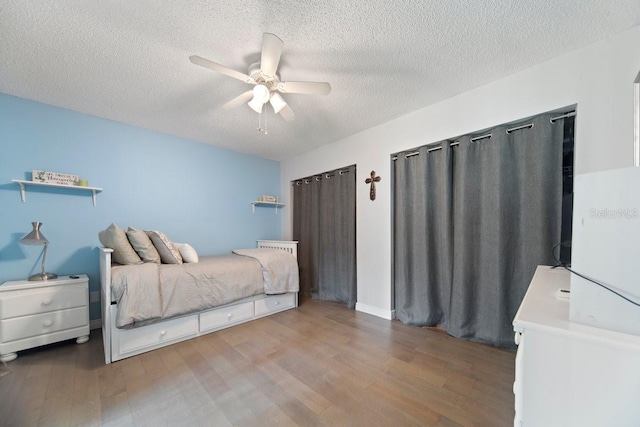 bedroom featuring a textured ceiling, ceiling fan, and hardwood / wood-style flooring