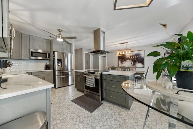 kitchen featuring island range hood, gray cabinetry, stainless steel appliances, pendant lighting, and sink