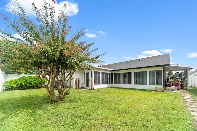 back of property featuring a yard and a sunroom