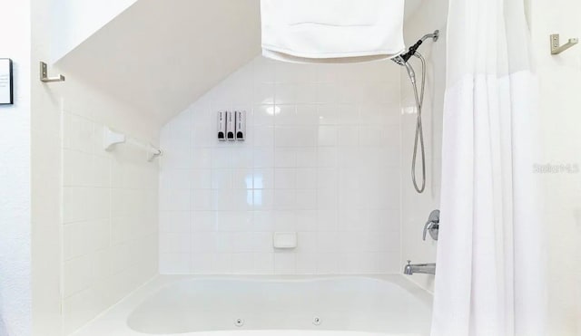 bathroom with shower / bath combo with shower curtain and vaulted ceiling