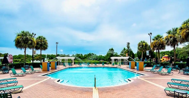 view of swimming pool with a pergola, pool water feature, and a patio area