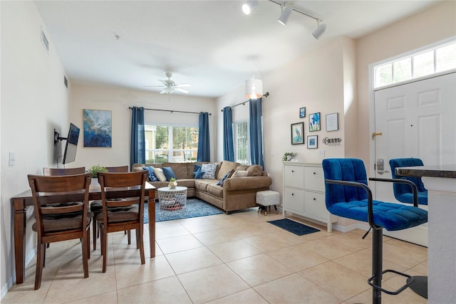 living room with light tile patterned floors, rail lighting, plenty of natural light, and ceiling fan