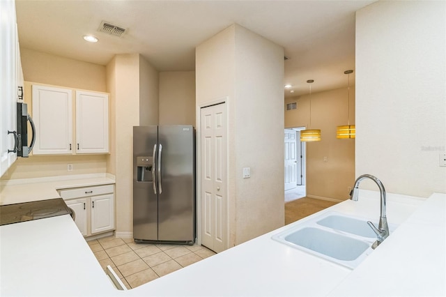 kitchen with pendant lighting, light tile patterned floors, sink, white cabinetry, and stainless steel appliances