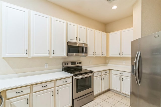 kitchen featuring white cabinets, stainless steel appliances, and light tile patterned floors