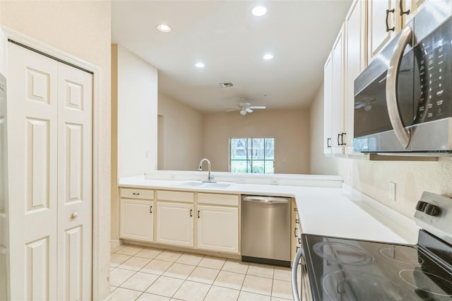 kitchen featuring light tile patterned flooring, sink, white cabinetry, appliances with stainless steel finishes, and ceiling fan