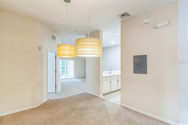 carpeted empty room with electric panel and sink