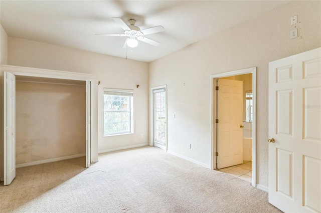 bedroom featuring ceiling fan, light colored carpet, and ensuite bath