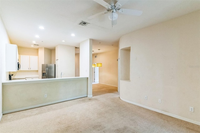 interior space with ceiling fan and light colored carpet