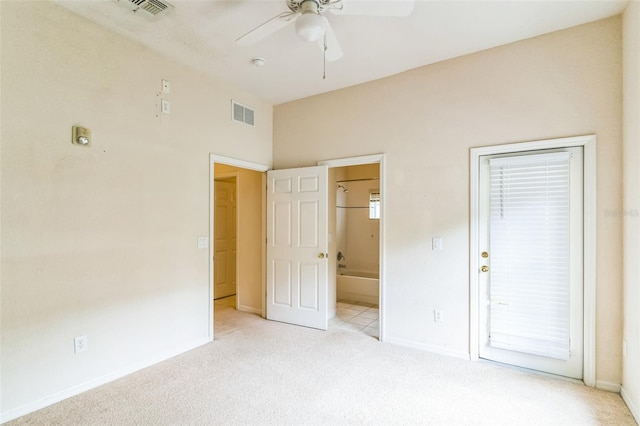 unfurnished bedroom featuring ceiling fan, light colored carpet, and ensuite bathroom