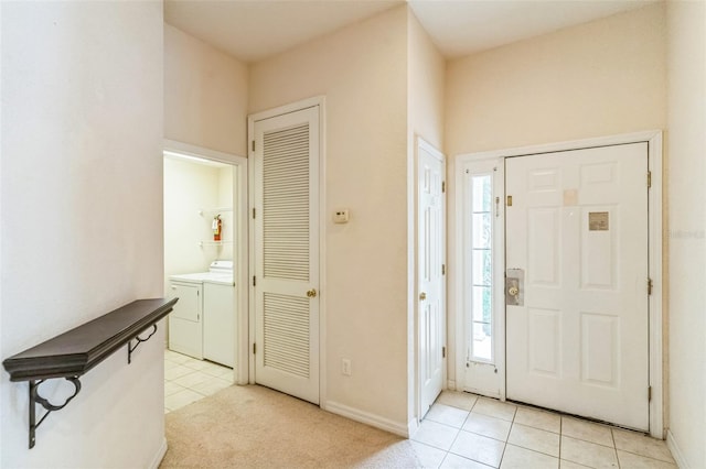 entryway featuring separate washer and dryer, light tile patterned floors, and a wealth of natural light