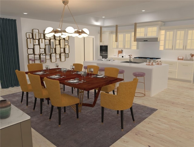 dining space featuring light hardwood / wood-style floors, a chandelier, and sink