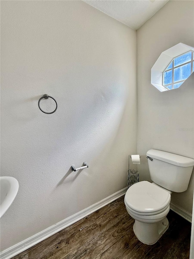 bathroom with toilet and hardwood / wood-style flooring