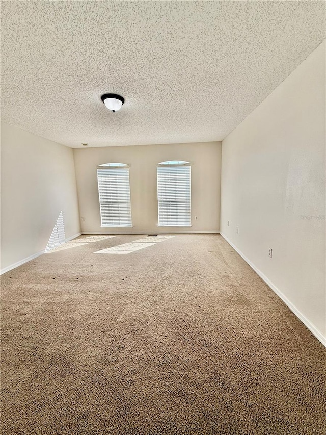 carpeted spare room with a textured ceiling