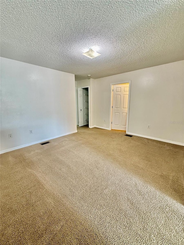 carpeted spare room featuring a textured ceiling