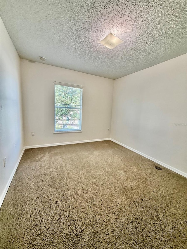 unfurnished room featuring carpet and a textured ceiling