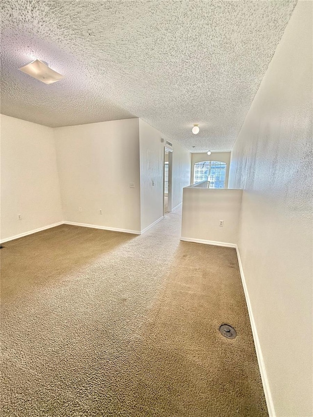 unfurnished room featuring a textured ceiling and carpet floors