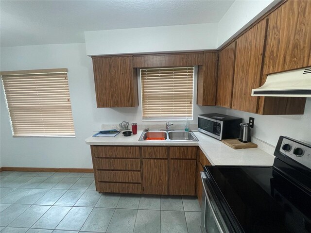 kitchen featuring light tile patterned floors, exhaust hood, stainless steel appliances, and sink