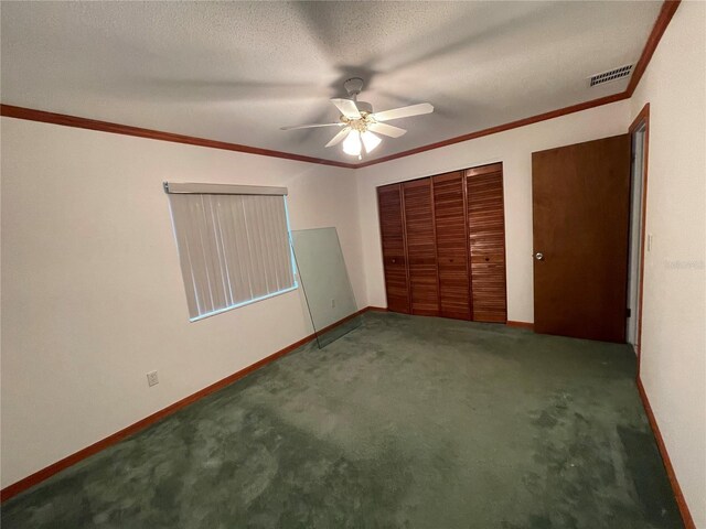 unfurnished bedroom with dark colored carpet, ceiling fan, crown molding, and a textured ceiling