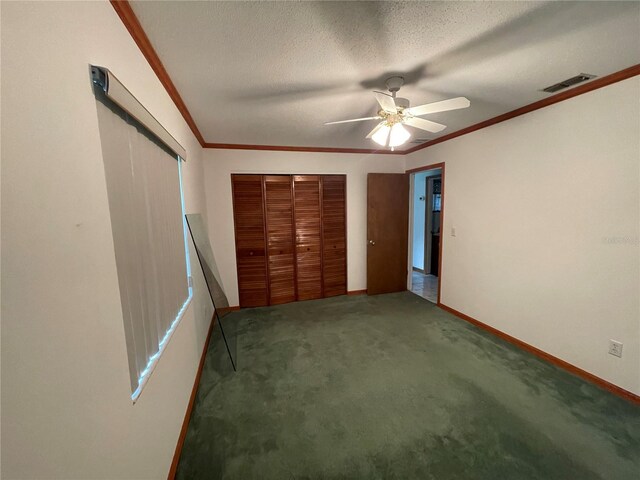 unfurnished bedroom with ceiling fan, carpet floors, a closet, and a textured ceiling