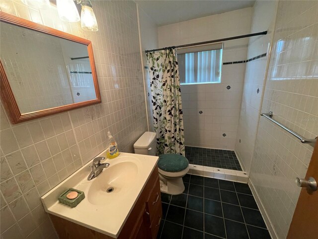 bathroom with tile walls, vanity, toilet, and a shower with shower curtain