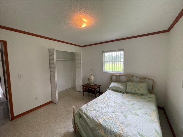 bedroom with ornamental molding, a closet, and a textured ceiling