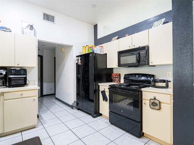 kitchen featuring white cabinetry, black appliances, and light tile patterned floors