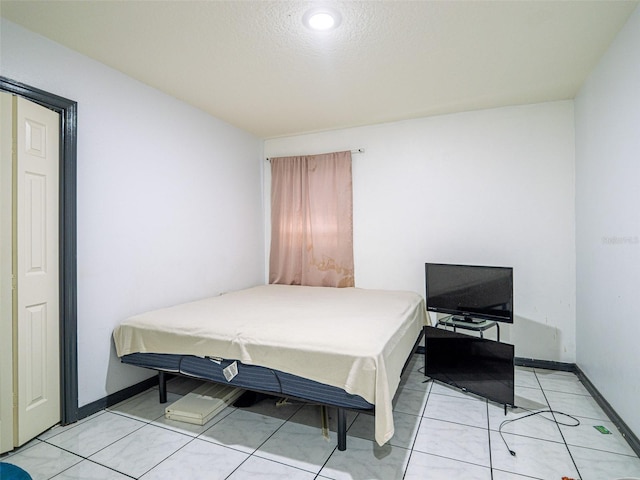 tiled bedroom featuring a textured ceiling