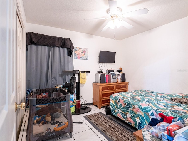 tiled bedroom with a textured ceiling, a closet, and ceiling fan